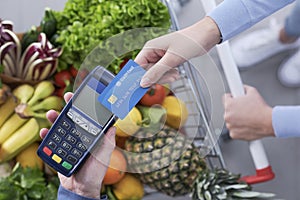 Woman paying for groceries using a credit card