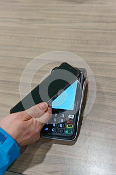 woman paying for her purchase in a store with her cell phone