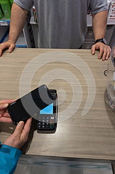 woman paying for her purchase in a store with her cell phone