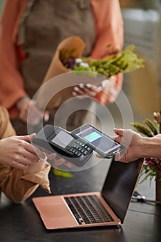 Woman Paying by NFC in Flower Shop