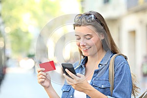 Woman paying online with a credit card outdoors