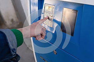 Woman paying for parking at teller machine in city