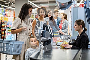 Woman paying with a smart watches in a grocery store