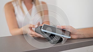 A woman pays using a non -contact payment of the NFC used by a smartphone.
