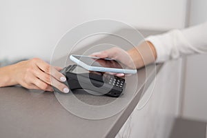 A woman pays using a non -contact payment of the NFC used by a smartphone.