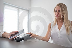 A woman pays using a non -contact payment of the NFC used by a smartphone.