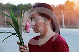 Woman peacefully smelling the pink lotus in bouquet.