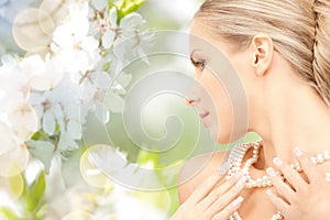 Woman with pearl necklace over cherry blossom