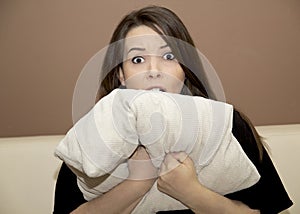 Woman peeking from behind the pillow