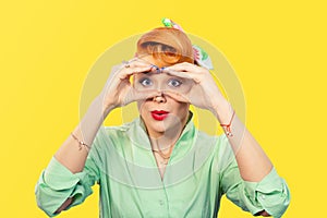 Woman peeking looking through fingers like binoculars