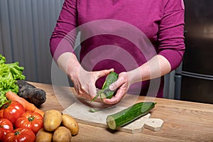 Woman peeling a cucumber for dinner