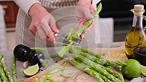 Woman peeling Fresh green organic natural asparagus at domestic kitchen