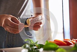 Woman peeling garlic whilst preparing dinner