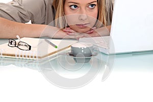 Woman peering at her laptop photo