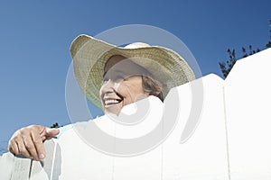 Woman Peering Over Garden Fence