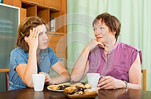 Woman pensioner having conversation with her daughter