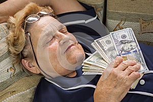 Woman pensioner sleeping with money in her hand