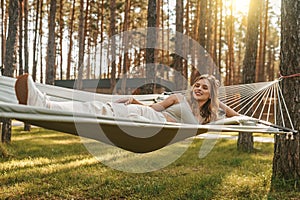 Woman in pensive mood relaxing on hammock