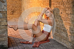 Woman with perfect legs resting near the castle wall.