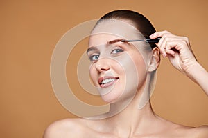 woman with perfect shape eyebrows on beige background.