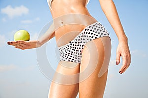 Woman perfect slim body holding an apple.