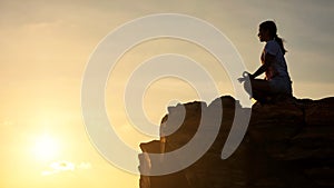 woman perform lotus yoga pose at cliff