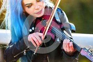 Woman perform music on violin park outdoor. Girl performing jazz.