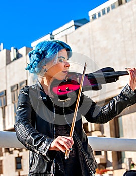 Woman perform music on violin park outdoor. Girl performing jazz .