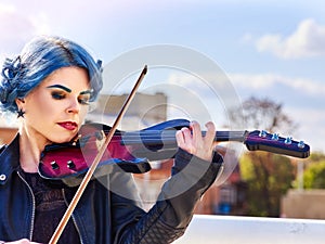 Woman perform music on violin park outdoor. Girl performing jazz.