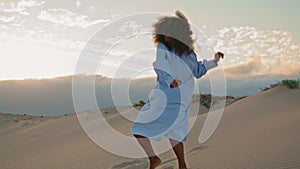 Woman performing contemporary style in sand desert summer evening. Girl dancing.