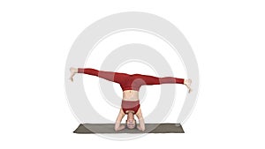 Woman performing a headstand with split on white background.