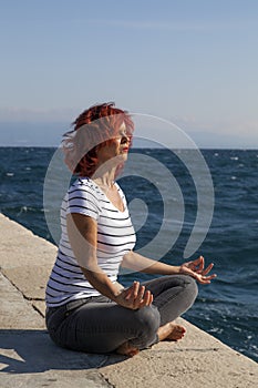 Woman performing joga on sea coast