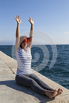 Woman performing joga on sea coast