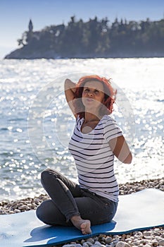 Woman performing joga on sea coast