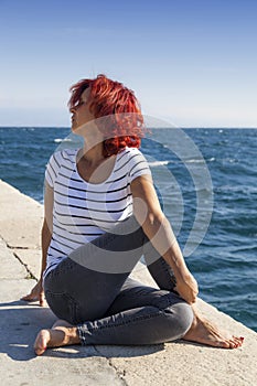 Woman performing joga on sea coast