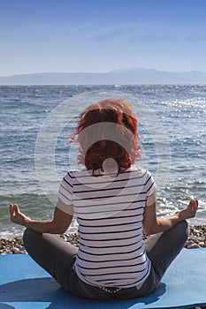 Woman performing joga on sea coast