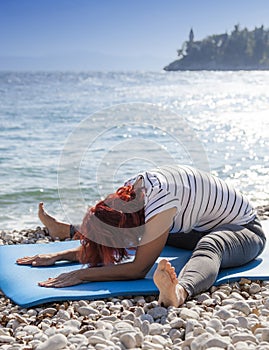 Woman performing joga on sea coast