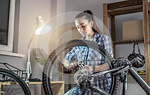 Woman is performing maintenance on his mountain bike. Concept of fixing and preparing the bicycle for the new season