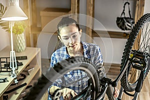 Woman is performing maintenance on his mountain bike. Concept of fixing and preparing the bicycle for the new season