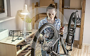 Woman is performing maintenance on his mountain bike. Concept of fixing and preparing the bicycle for the new season