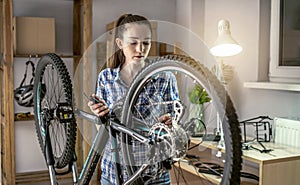 Woman is performing maintenance on his mountain bike. Concept of fixing and preparing the bicycle for the new season