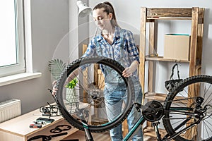 Woman is performing maintenance on his mountain bike. Concept of fixing and preparing the bicycle for the new season