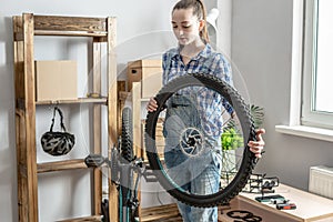Woman is performing maintenance on his mountain bike. Concept of fixing and preparing the bicycle for the new season