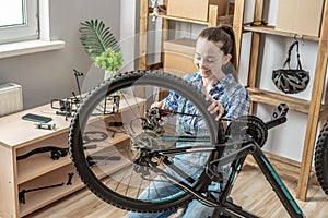 Woman is performing maintenance on his mountain bike. Concept of fixing and preparing the bicycle for the new season