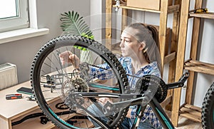 Woman is performing maintenance on his mountain bike. Concept of fixing and preparing the bicycle for the new season