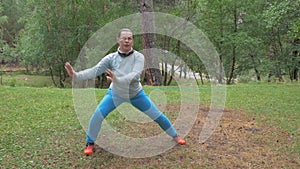 A woman is performing oriental exercises in a clearing in the forest. Yoga and meditation, a healthy lifestyle. slow