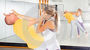 Woman performing palm heel strike while training in gym