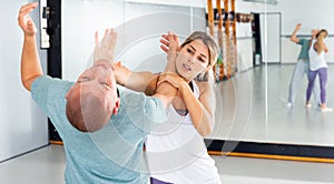 Woman performing palm heel strike while training in gym