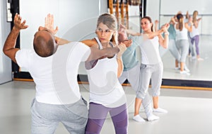 Woman performing palm heel strike while training in gym