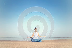 Woman performing relaxation and meditation exercises at the sea